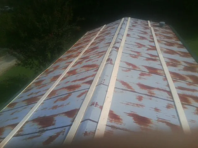 Rusted metal roof panels with new wood purlins before replacement — Storm Damage Roof Repair in Skippers by Roofing Brothers