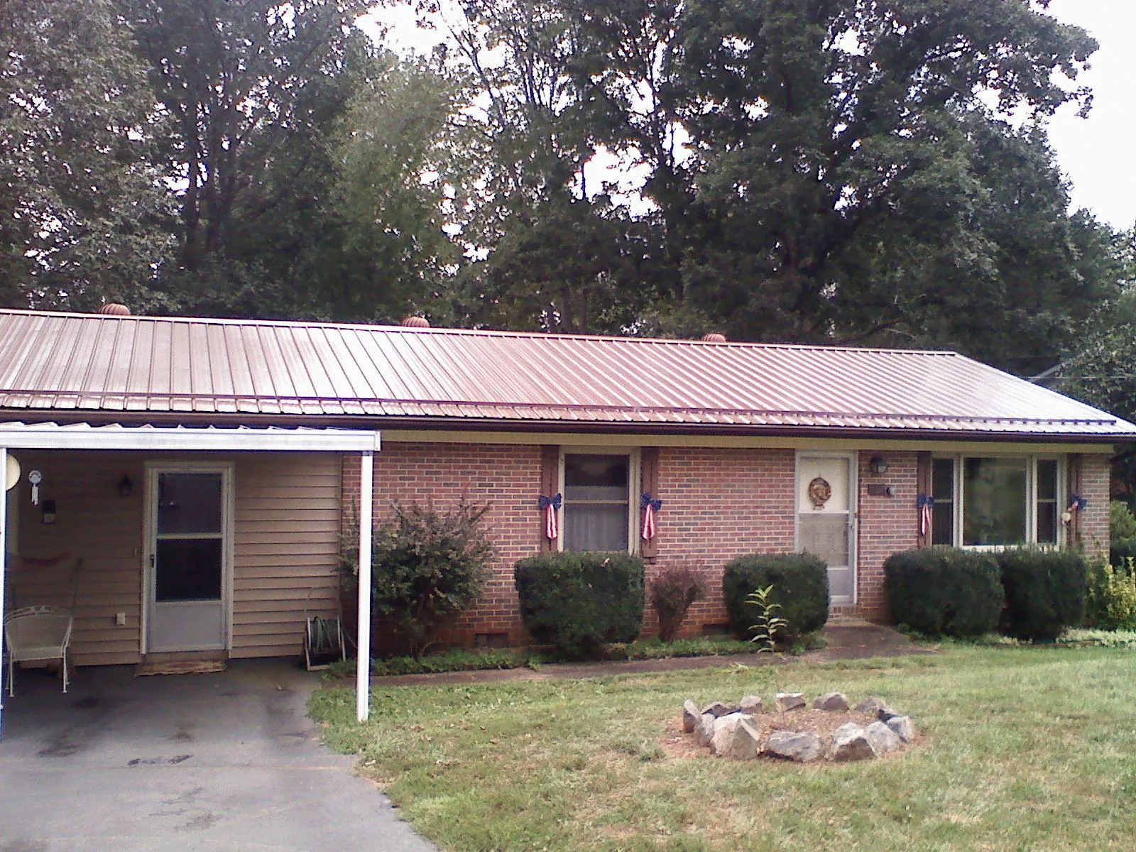 Bronze metal roof and carport on a brick ranch home — Roof Repair work by our crew in Skippers